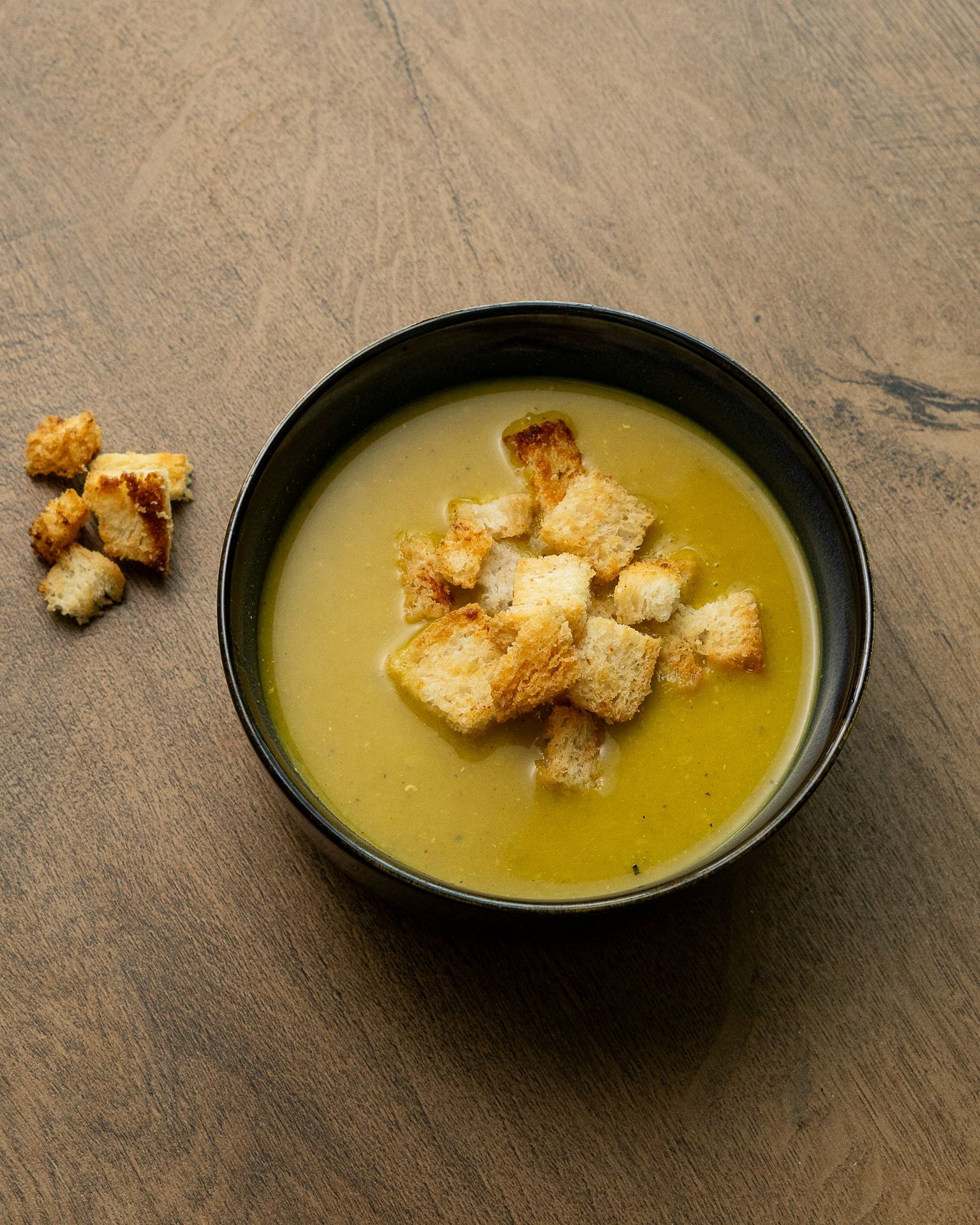 Bowl of creamy soup topped with croutons